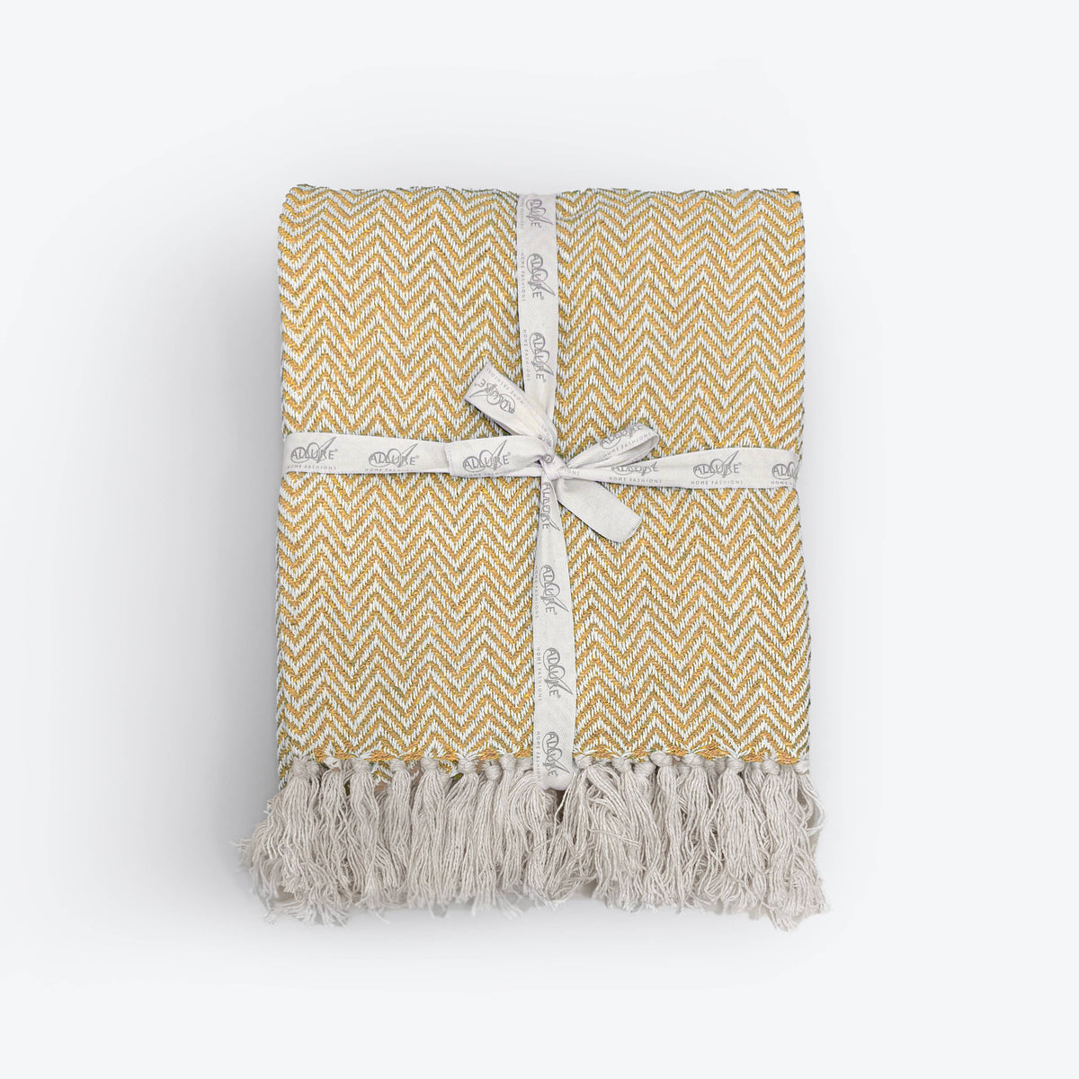 Moorland Herringbone Cotton Throw in Moss laid across a bed, Croft & Cleo
