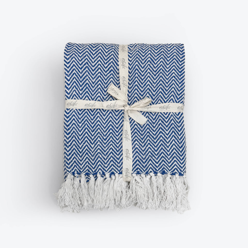 Corner detail of the Moorland Herringbone Cotton Throw showing the tasselled fringe, Croft & Cleo