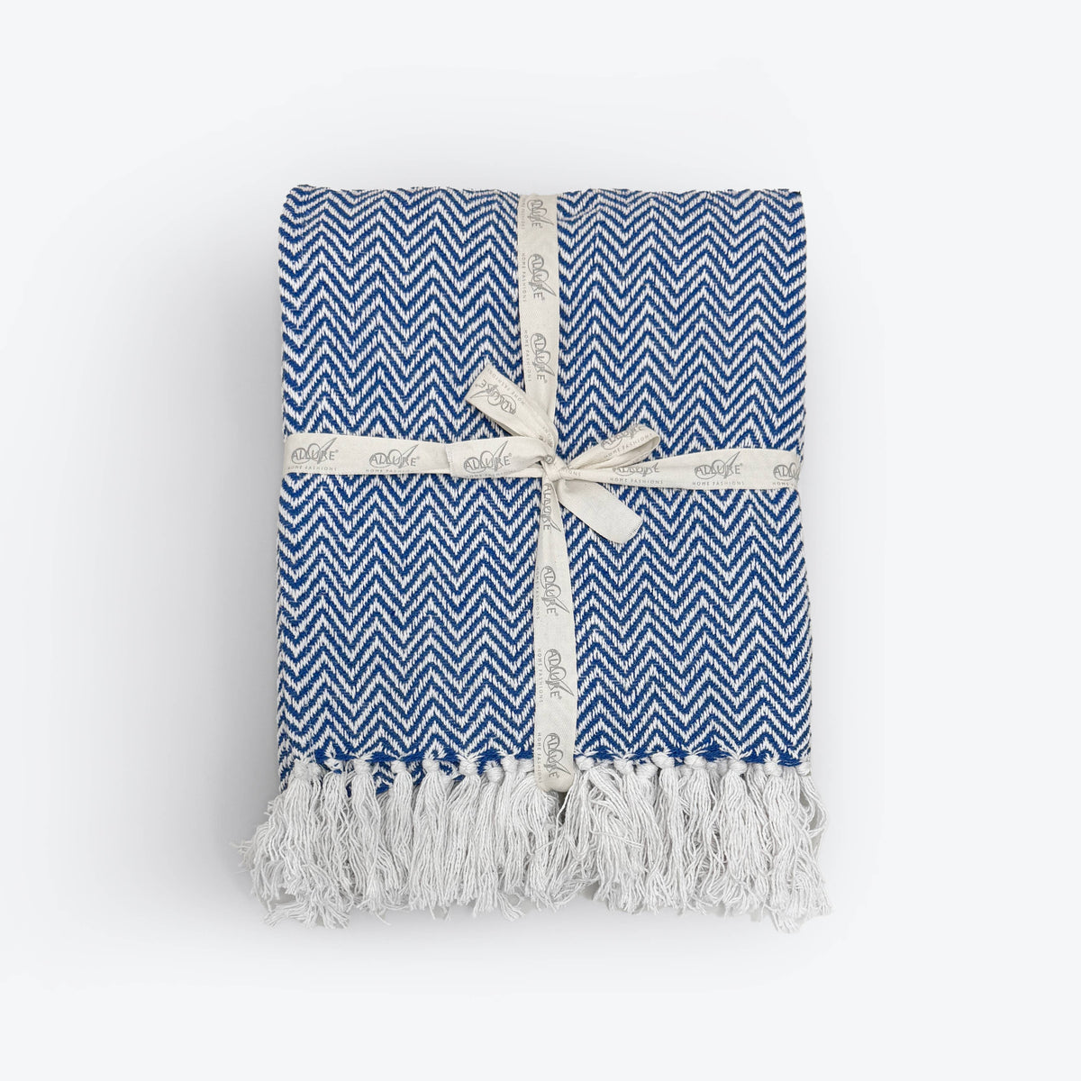 Corner detail of the Moorland Herringbone Cotton Throw showing the tasselled fringe, Croft & Cleo