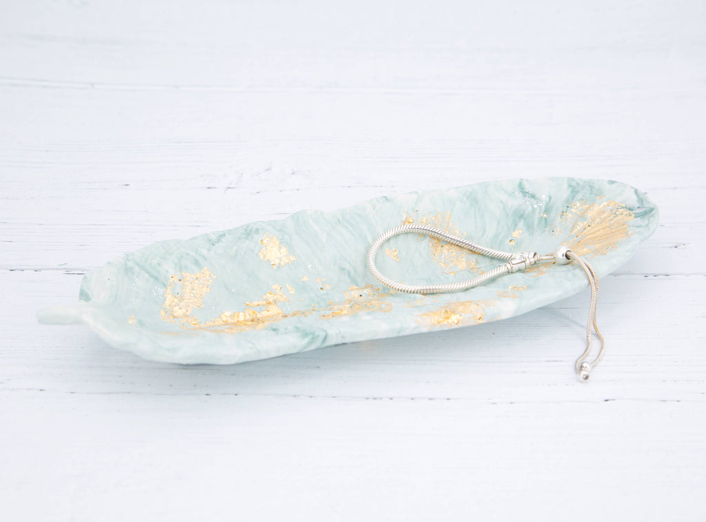 Zen green and gold leaf Jesmonite feather displayed on mantlepiece or shelf, Croft & Cleo