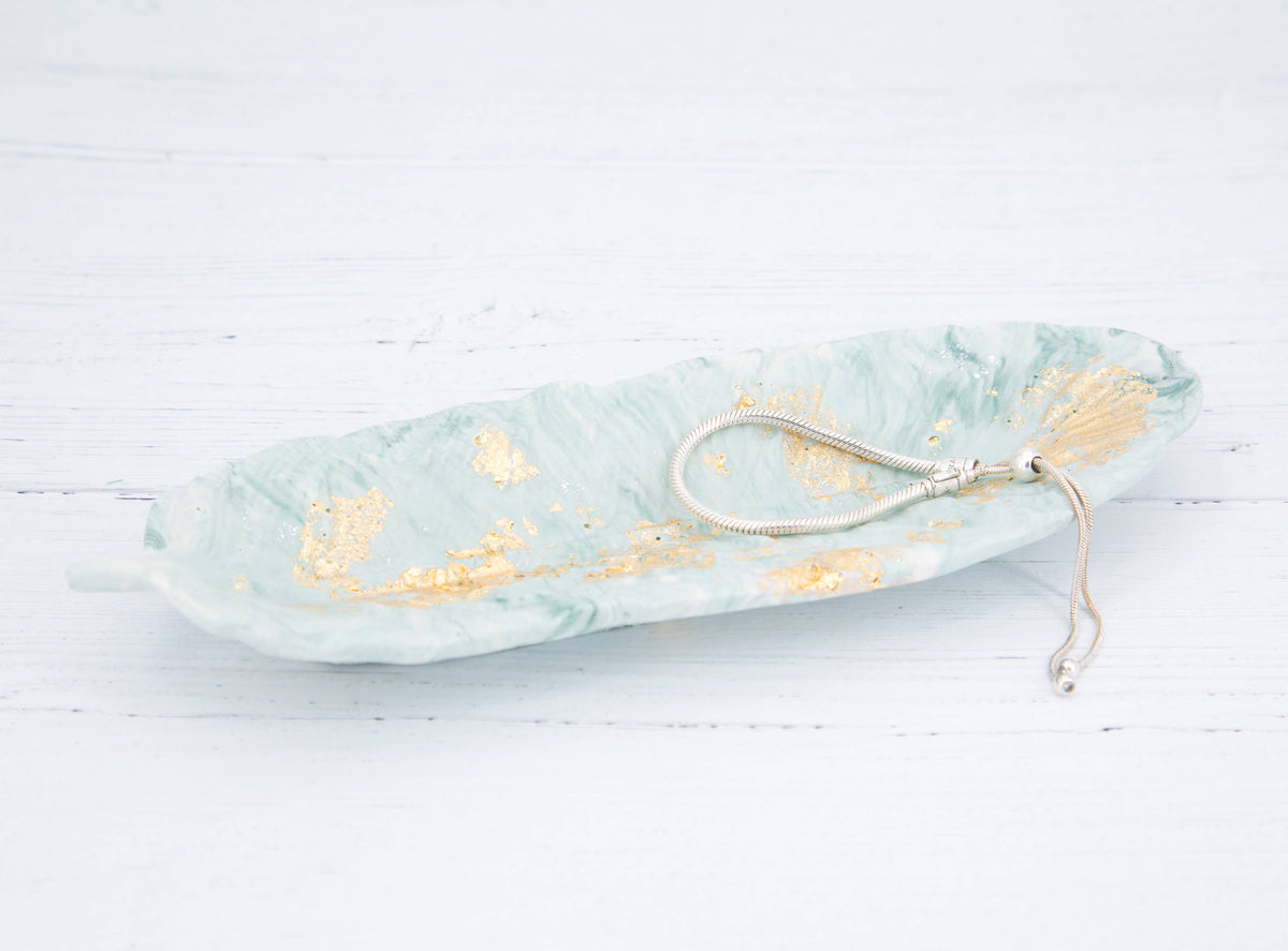 Zen green and gold leaf Jesmonite feather displayed on mantlepiece or shelf, Croft & Cleo