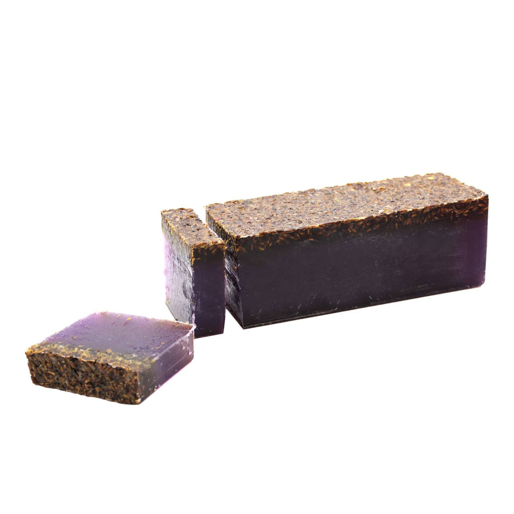 Dark charcoal-toned soap bar with a purple base layer, cut to show texture and colour
