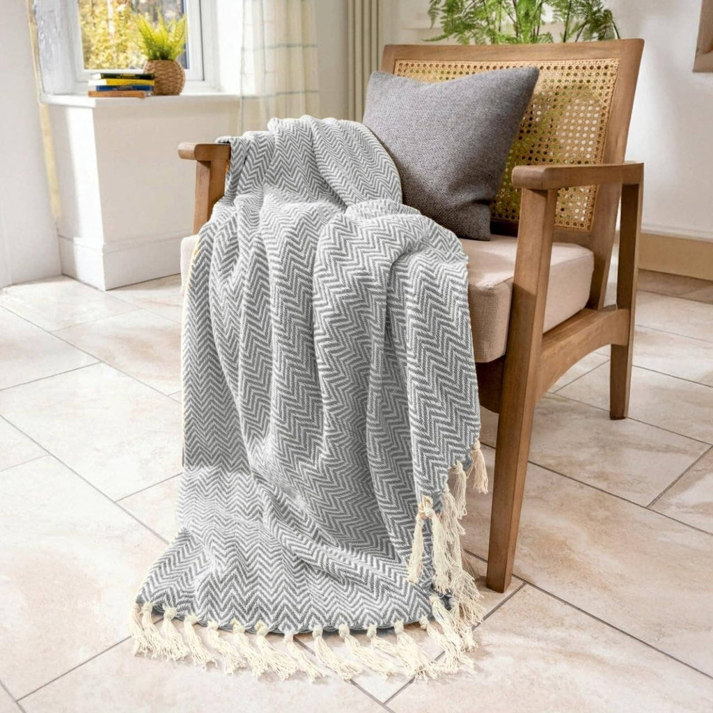 Moorland Herringbone Cotton Throw in Moss draped over a sofa arm, Croft & Cleo