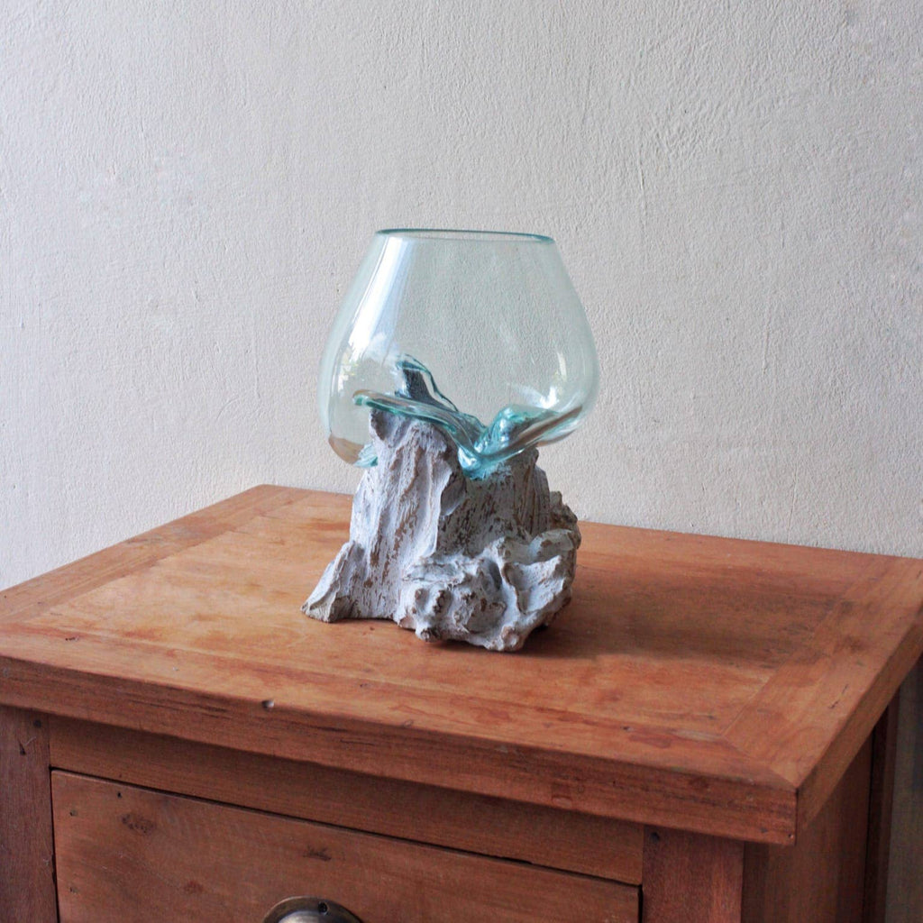 Side view of large molten glass bowl on wooden base showing unique organic form