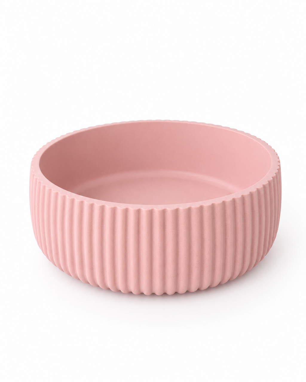 A pink ribbed ceramic bowl with a fluted exterior and smooth interior, shown on a clean white background.