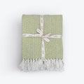 Moorland Herringbone Cotton Throw in Stone laid across a bed, Croft & Cleo