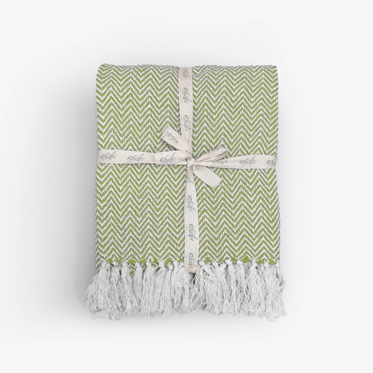 Moorland Herringbone Cotton Throw in Stone laid across a bed, Croft & Cleo