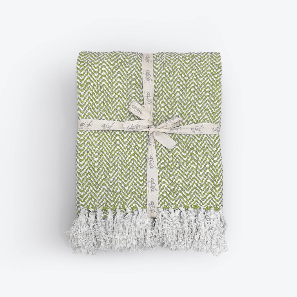 Moorland Herringbone Cotton Throw in Moss, folded to show the herringbone weave and tasselled fringe, Croft & Cleo