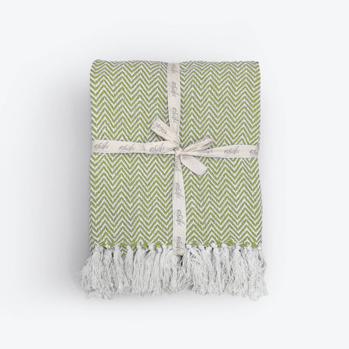 Moorland Herringbone Cotton Throw in Moss, folded to show the herringbone weave and tasselled fringe, Croft & Cleo