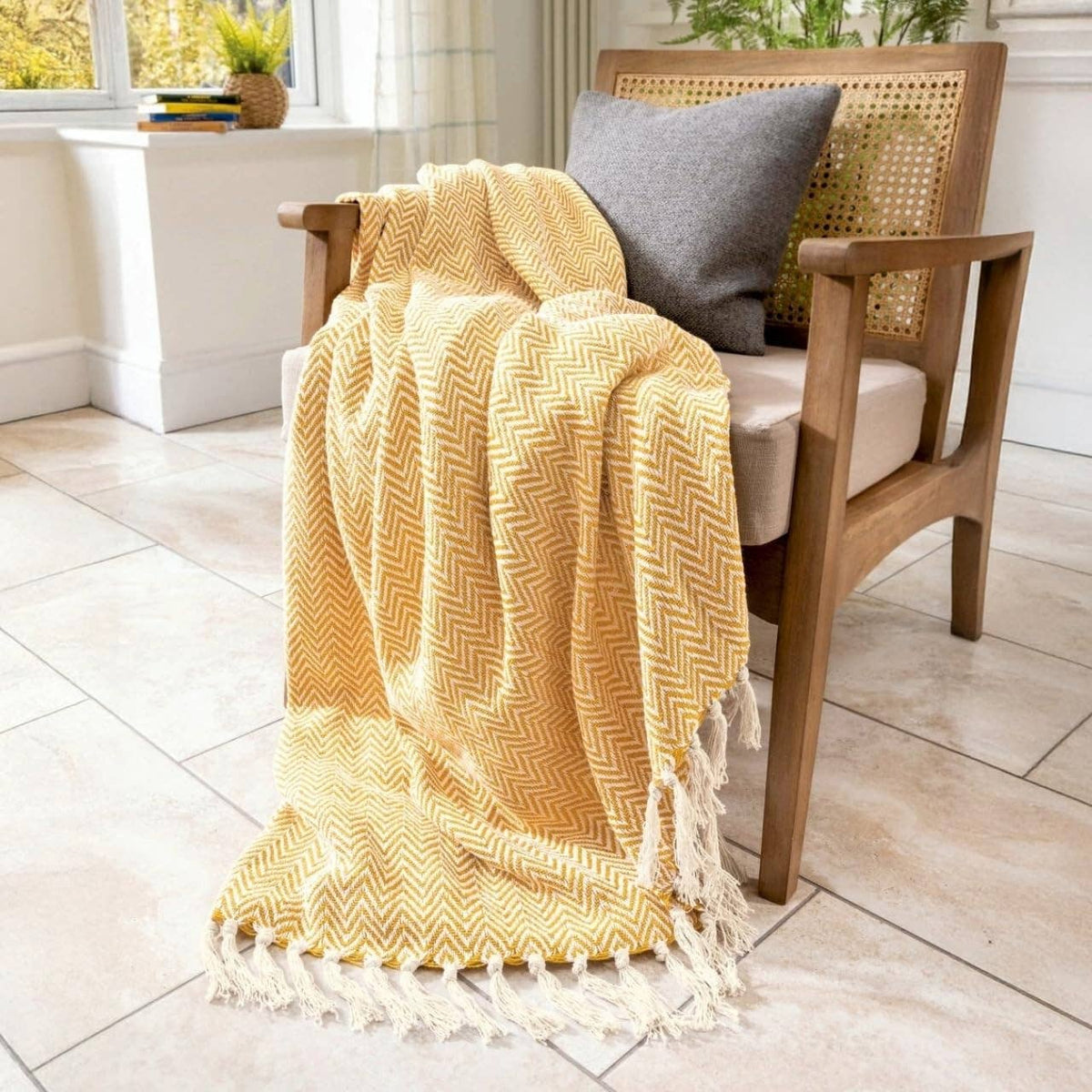 Moorland Herringbone Cotton Throw in Moss laid across a bed, Croft & Cleo